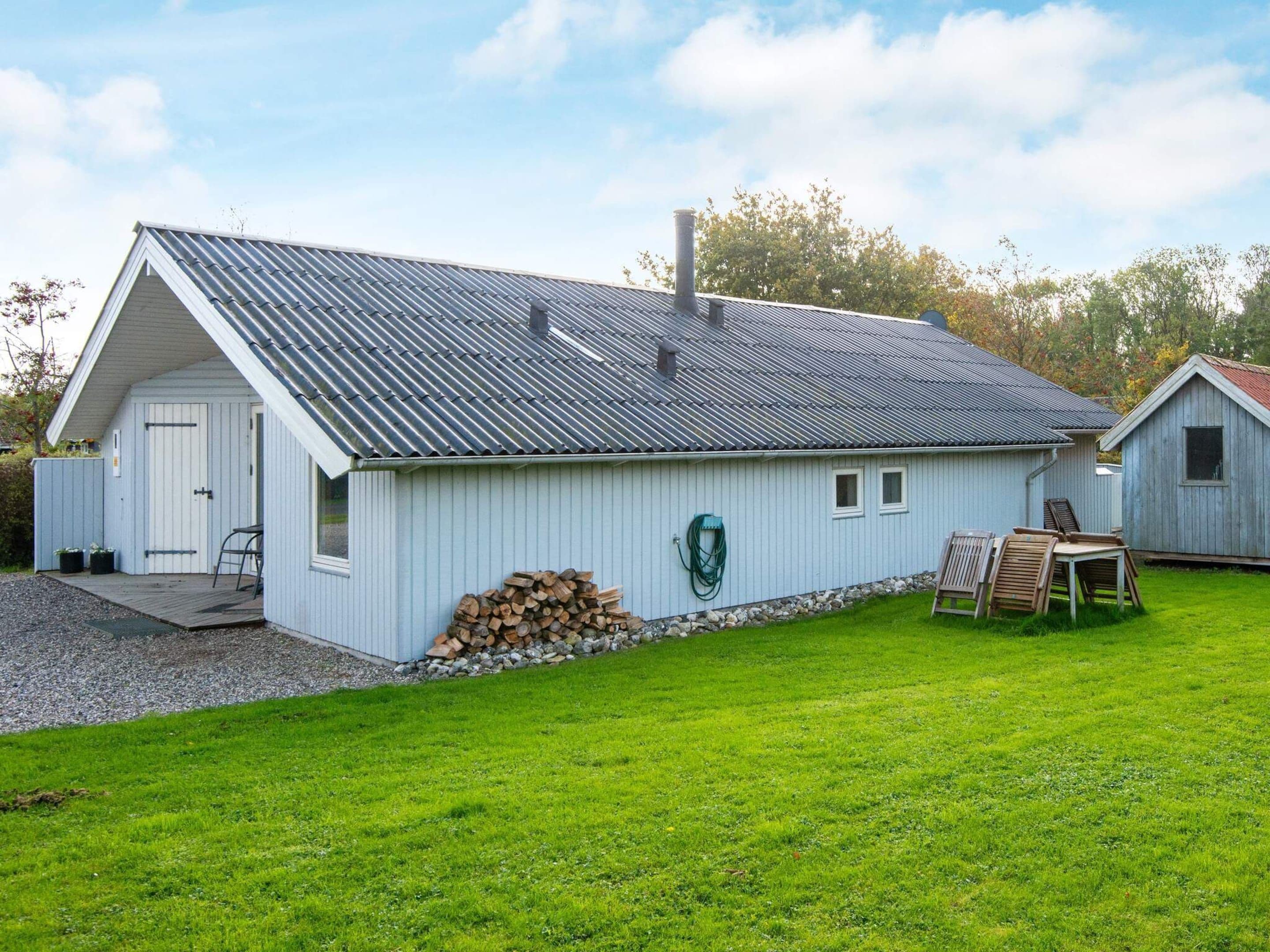 A single-story building with a sloped metal roof, a door, and a small window.