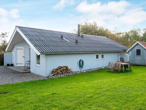 A single-story building with a sloped metal roof, a door, and a small window.