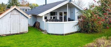 A house with a covered patio, a fenced yard, and a garage.