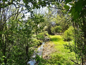 A natural landscape with a stream, dense foliage, and a grassy area. - 4 Person Holiday Home in Broager (Broager)