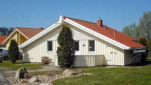 Yhden kerroksen talo, jossa on punatiilinen katto, savupiippu ja satelliittiantenni.