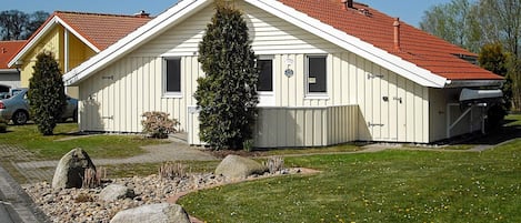 A single-story house with a red-tiled roof, a chimney, and a satellite dish.