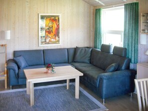 A living room with a sofa, a coffee table, and a painting on the wall.