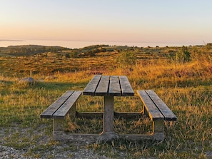 A wooden picnic table in a grassy field with a view of the horizon. - 7 Person Holiday Home in Knebel (Knebel)