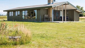 A modern house with a large glass window, a covered patio, and a chimney. - 7 Person Holiday Home in Knebel (Knebel)