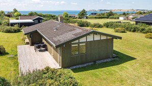 Un bâtiment d’un seul étage, doté d’un toit en pente, d’une terrasse et offrant une vue sur la mer.