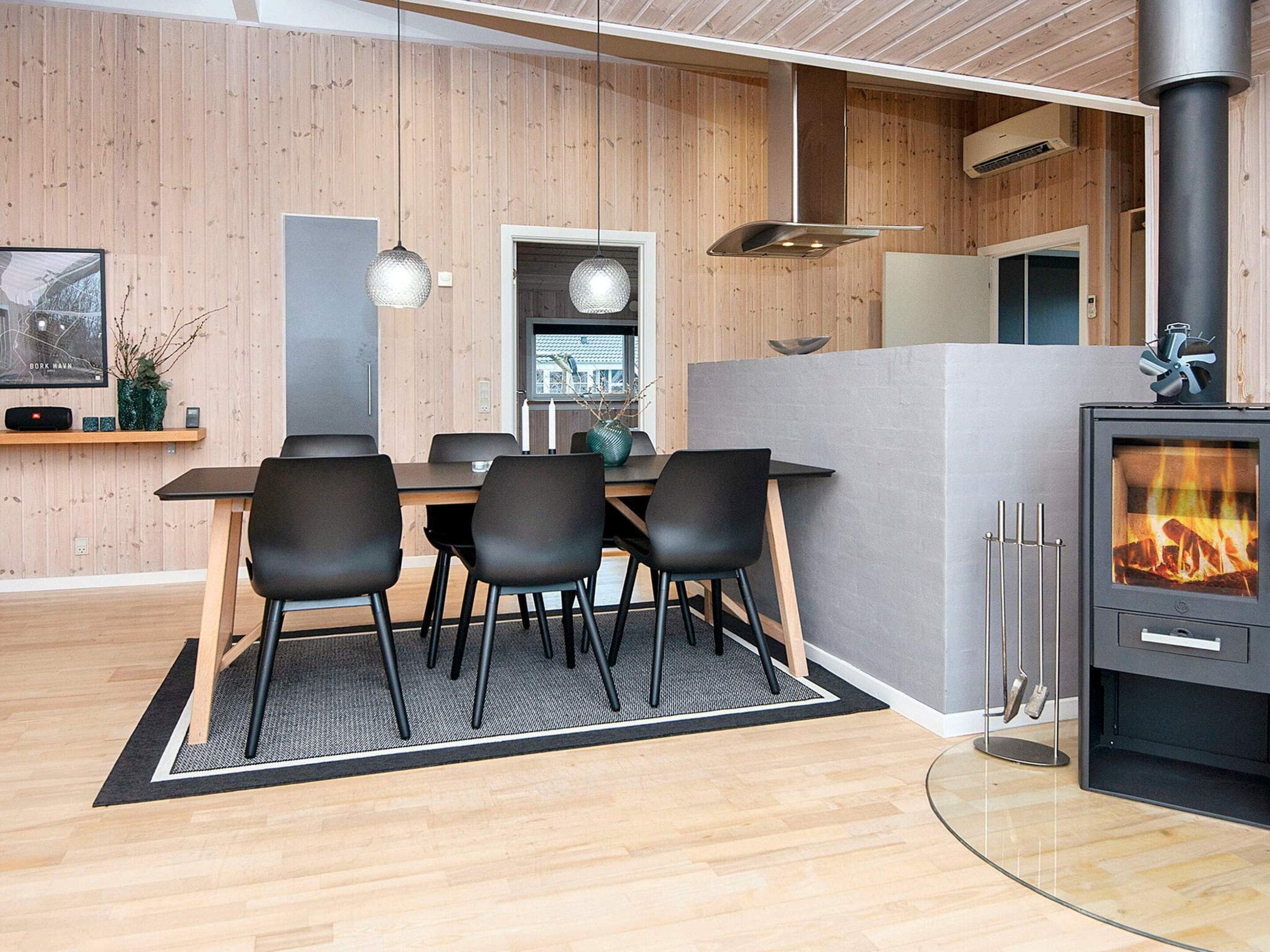 A modern interior with a dining area, a fireplace, and a kitchen.