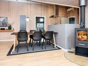 A modern interior with a dining area, a fireplace, and a kitchen.