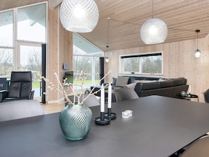 Et moderne interiør med et stort spisebord, en sofa og et fjernsyn.