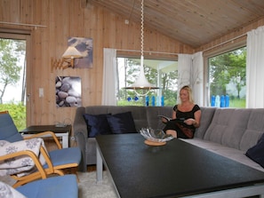A cozy room with a grey sofa, a table with a glass bowl, and a lamp. - 4 Star Holiday Home in Nexo (Nexø)