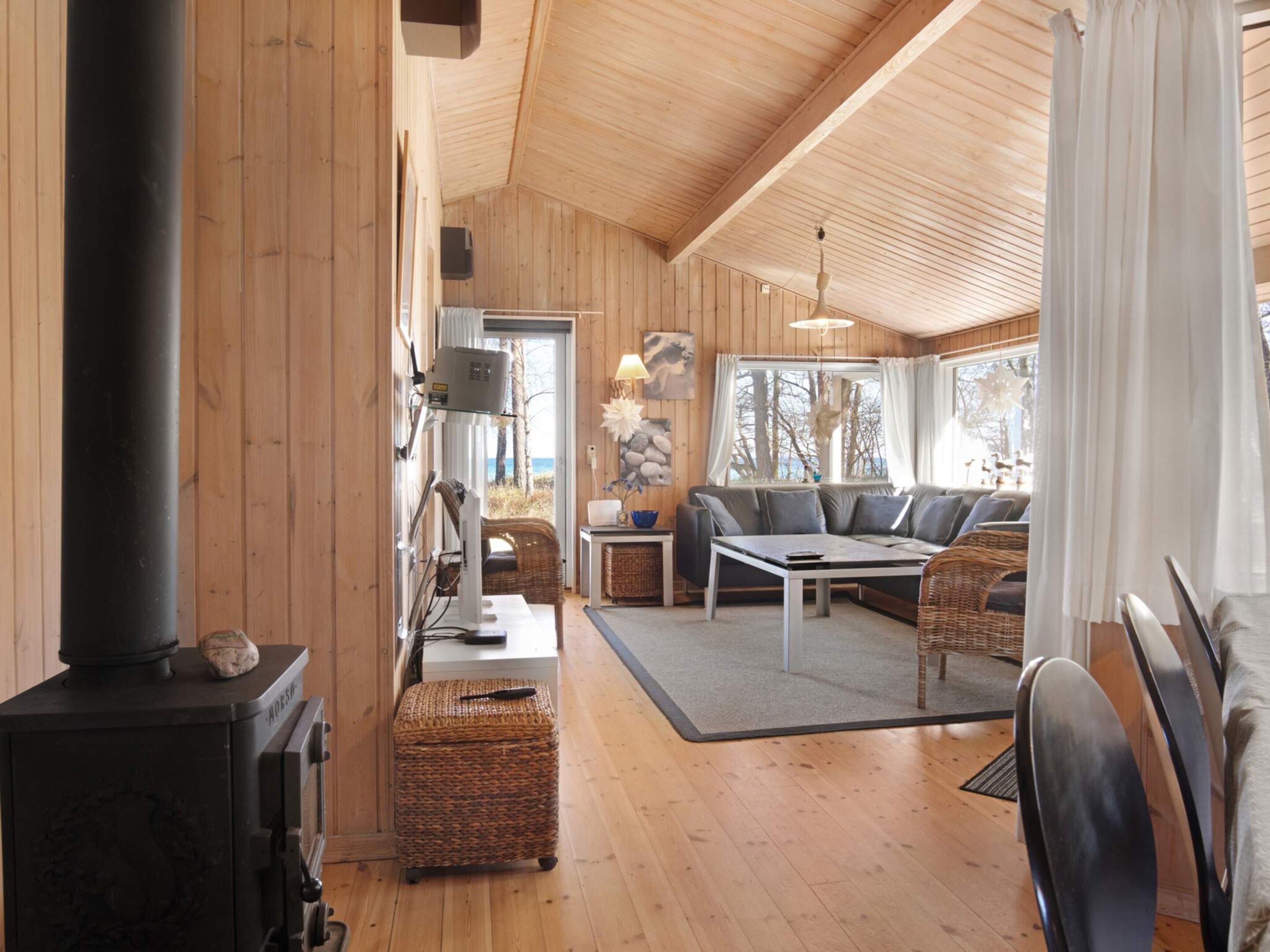 A cozy cabin interior with a fireplace, seating area, and a view of the outdoors.