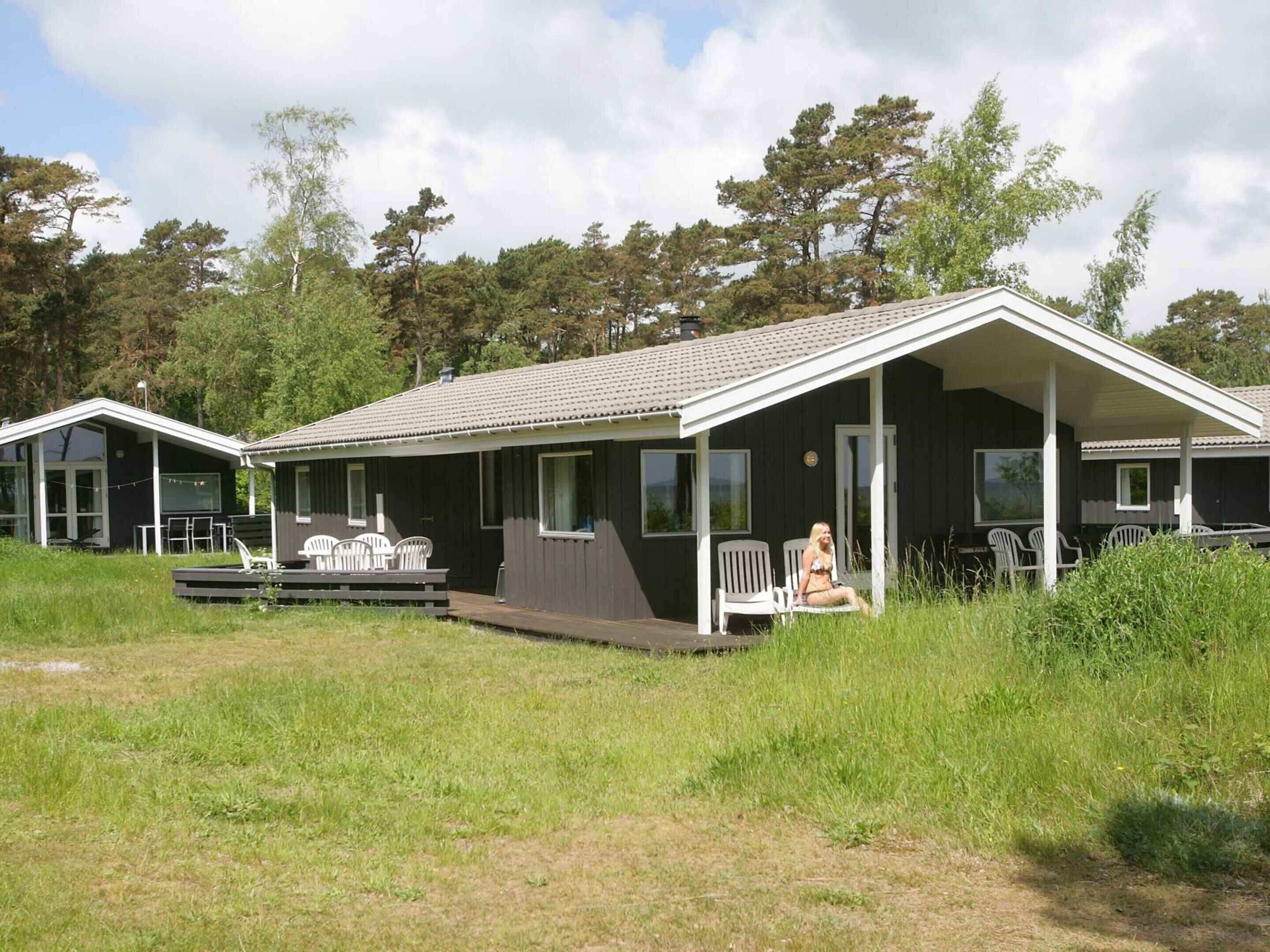 En toetages hytte med veranda, udendørs siddepladser og en terrasse.