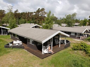 A row of cabins with a covered porch and outdoor seating area. - 4 Star Holiday Home in Nexo (Nexø)