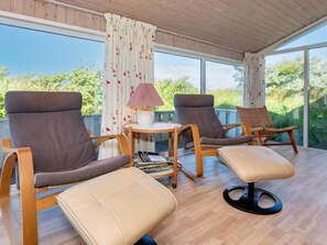 A sunlit room with two lounge chairs, a small table, and a magazine rack. - 12 Person Holiday Home in Hjorring (Hjørring)
