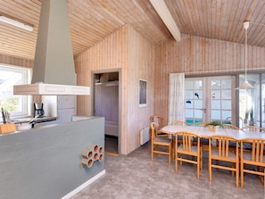A wooden interior with a kitchen area, dining table, and chairs. - 12 Person Holiday Home in Hjorring (Hjørring)