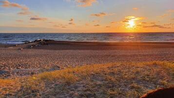 A beach with a rocky shoreline and a sunset.