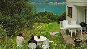 A house with a patio overlooking a lake and mountains. - 4 Person Holiday Home in Høyheimsvik (Luster)