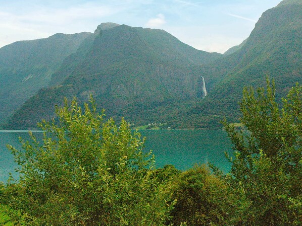 A mountainous landscape with a lake and trees in the foreground.