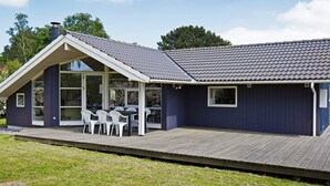 A modern house with a covered patio, a large window, and a deck. - Cozy Holiday Home in AsnÃ¦s near Fishing (Asnaes)