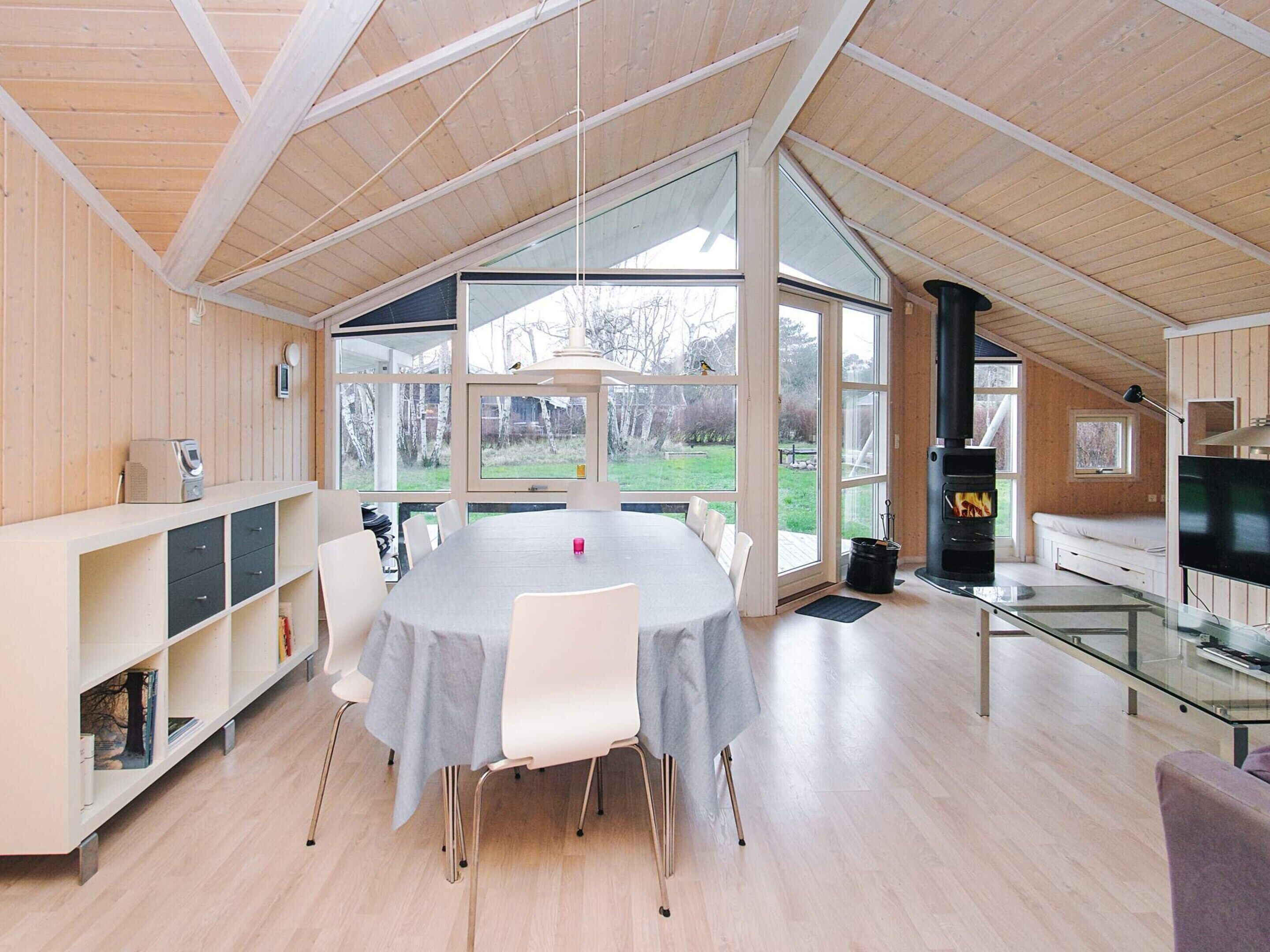 A spacious room with a large dining table, a fireplace, and a TV.
