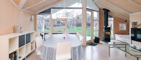 Una habitación amplia con una gran mesa de comedor, una chimenea y un televisor.
