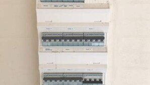 A wall-mounted electrical panel with multiple circuit breakers.