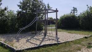 A playground with a wooden climbing structure and a slide. - 4 Star Holiday Home in Hemmet (Hemmet)