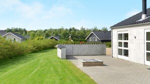 A residential area with houses, a paved driveway, and a grassy lawn. - 4 Star Holiday Home in Hemmet (Hemmet)