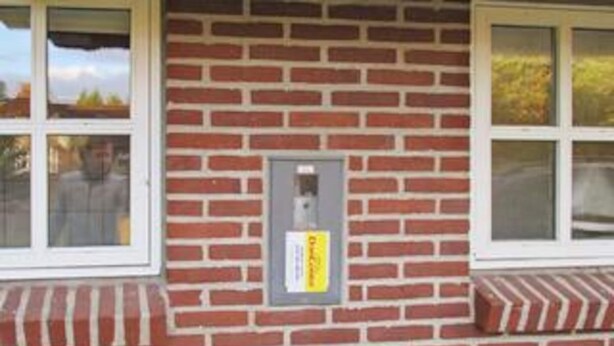 A brick building with a window, a door, and a small sign on the wall. - 8 Person Holiday Home in Blavand (Blavand)