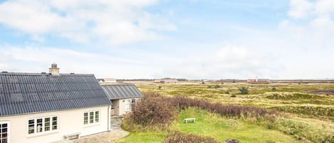 A house with a sloped roof and a fenced yard.
