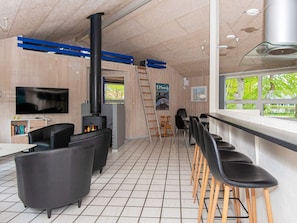 A modern interior with a fireplace, bar area, and seating. - 5 Star Holiday Home in Glesborg (Glesborg)
