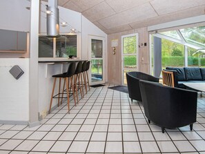 Une cuisine moderne dotée d’un bar, d’un coin repas avec un canapé et offrant une vue sur l’extérieur.