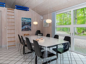 Une salle de conférence dotée d’une grande table, de chaises et offrant une vue sur la verdure grâce à de larges fenêtres.