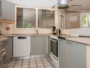 A compact kitchen with a dishwasher, oven, and a coffee maker.