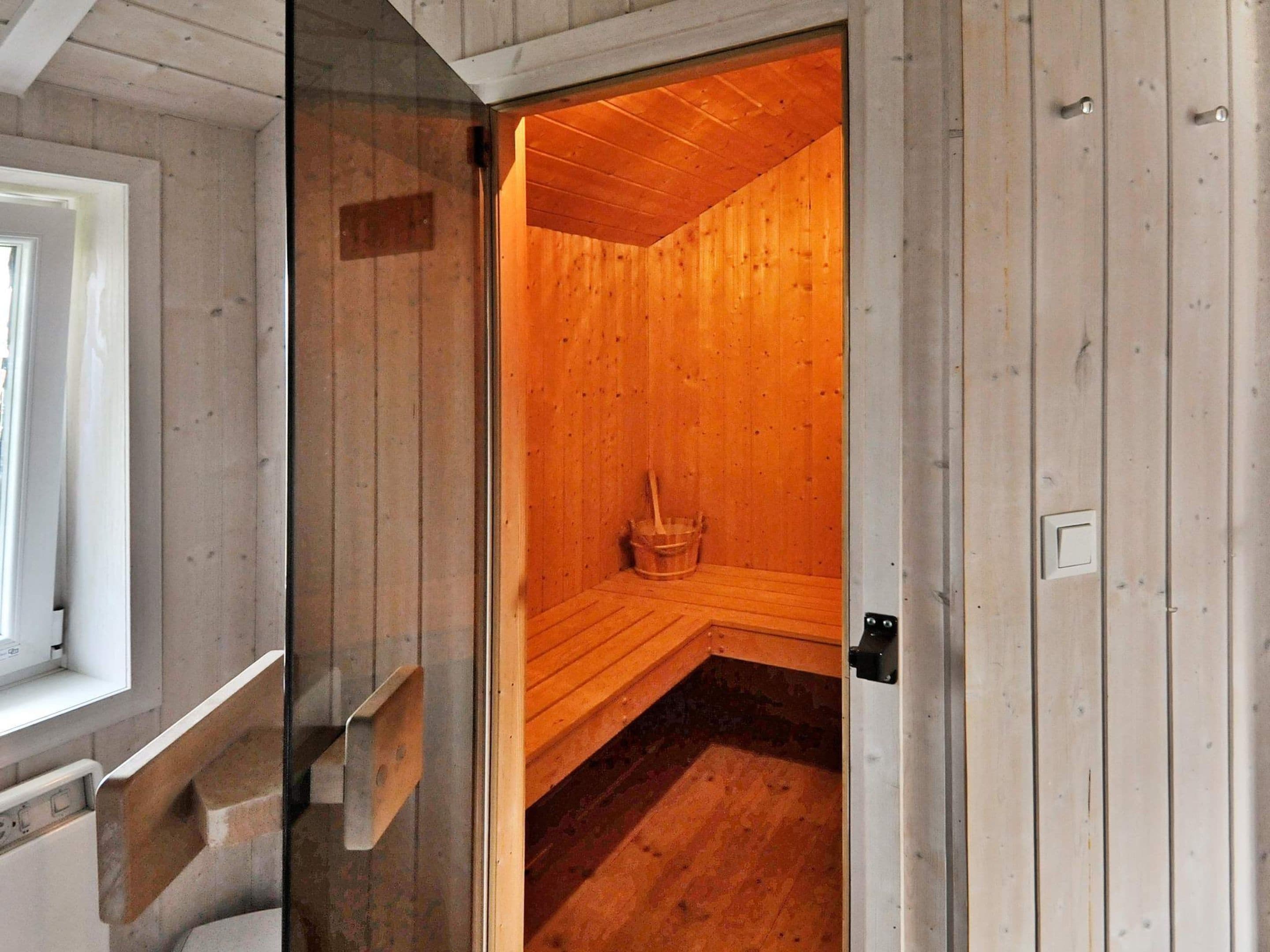 A sauna room with wooden walls and a bench.