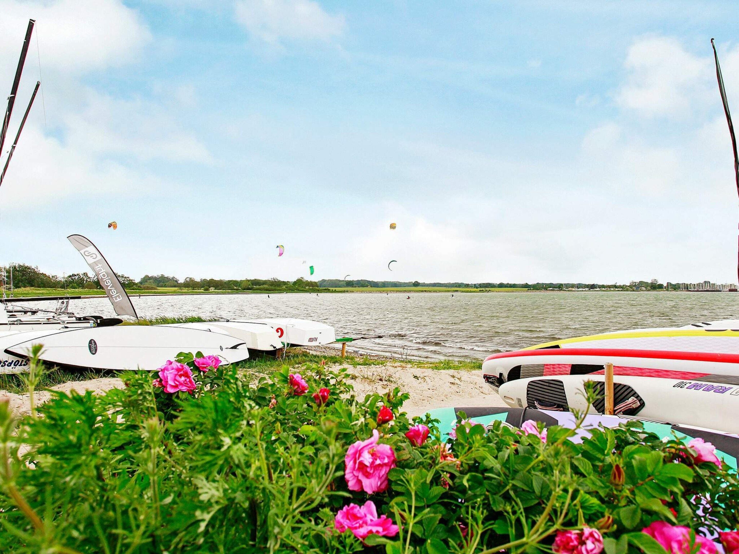 Une vue sur le lac, avec des bateaux et des pratiquants de kitesurf.