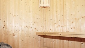 A sauna room with wooden walls and benches.