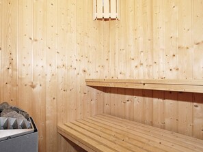 A sauna room with wooden walls and benches.