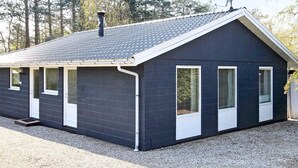 Un bâtiment d’un seul étage, à l’extérieur sombre, doté d’un toit à deux versants et d’une cheminée.