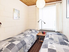 A room with two beds, a window with curtains, a lamp, and a painting on the wall. - 6 Person Holiday Home in Millinge (Millinge)