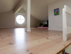 A room with a sloped ceiling, a large window, and a wooden floor. - 5 Star Holiday Home in Nysted (Nysted)