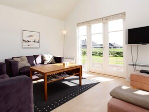 A modern living room with a sofa, a coffee table, and a television. - 5 Star Holiday Home in Nysted (Nysted)