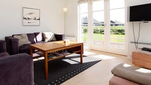 A modern living room with a sofa, a coffee table, and a television. - 5 Star Holiday Home in Nysted (Nysted)