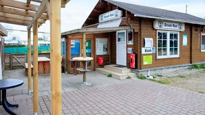 A wooden building with a sign reading 'Strand-Mast' and a 'Kiosk' sign.