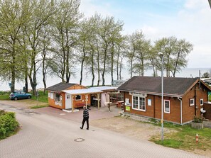 Un edificio de madera con un letrero que dice 'Kiosk' y un hombre caminando por un sendero pavimentado.