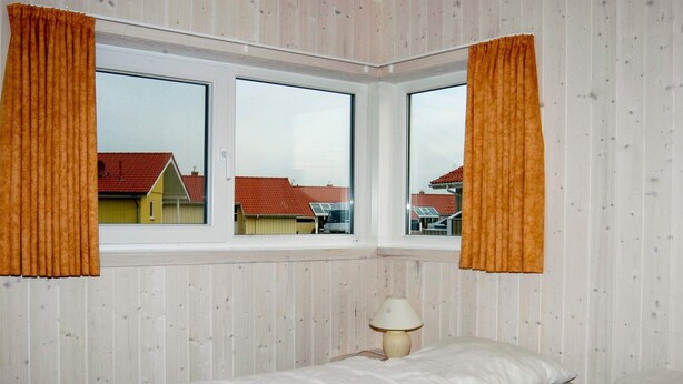Une chambre à coucher avec un lit, une fenêtre et une lampe.