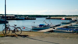 Un port de plaisance avec des bateaux amarrés, un vélo et un ciel dégagé.
