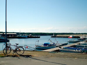 Un puerto deportivo con barcos amarrados, una bicicleta y un cielo despejado.