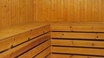 A wooden interior with a sloped ceiling and a corner bench.