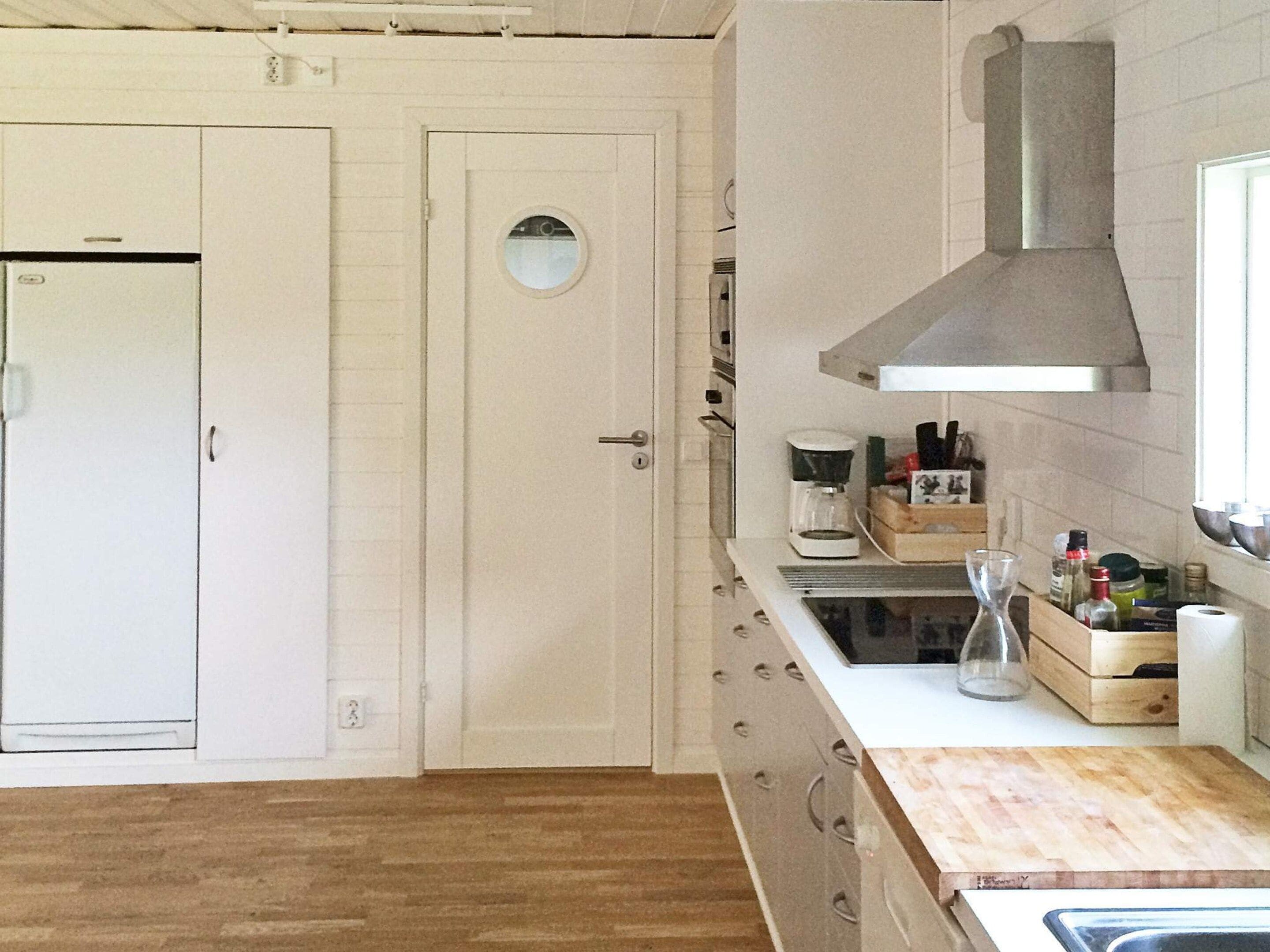 A kitchen with a built-in oven, a coffee maker, and wooden countertops.